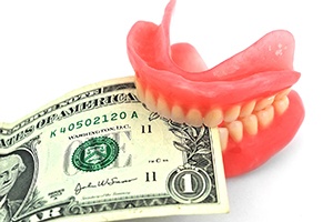 Denture in Lakewood, CO with a dollar bill between its teeth