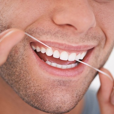A man flossing his teeth