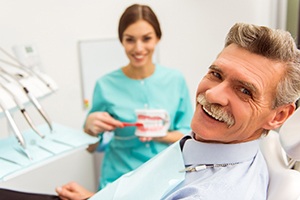 An older man receiving dentures at a dentist’s office