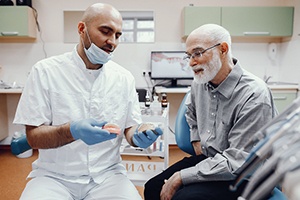 An elderly man talking with his dentist about dentures