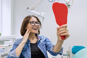 Young woman admiring her new dental implants in Lakewood