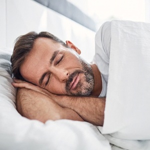 older man sleeping with nightguard for bruxism in Lakewood