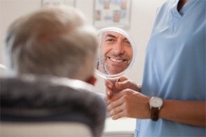 : Man checking face in mirror after Opus laser treatment in Lakewood, CO