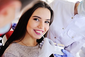 Dentist matching veneers to woman’s natural teeth