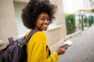 person smiling and walking down a street