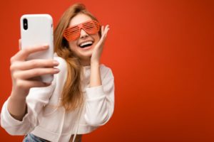 smiling woman recording herself on smartphone 