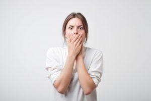 scared woman covering mouth 