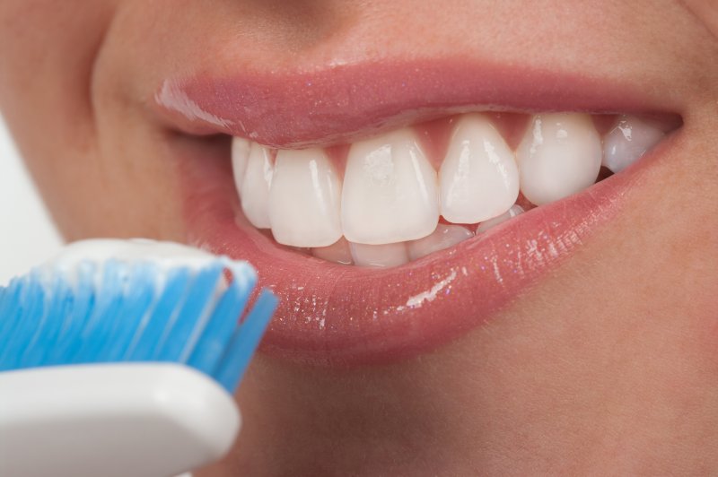 Woman bringing toothbrush to mouth