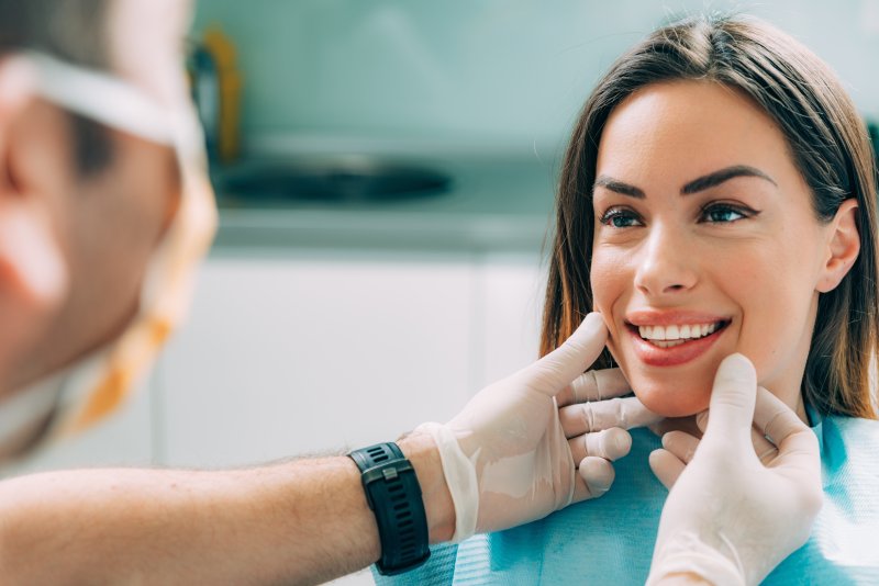 A woman smiling at her dentist after cosmetic dentistry treatment